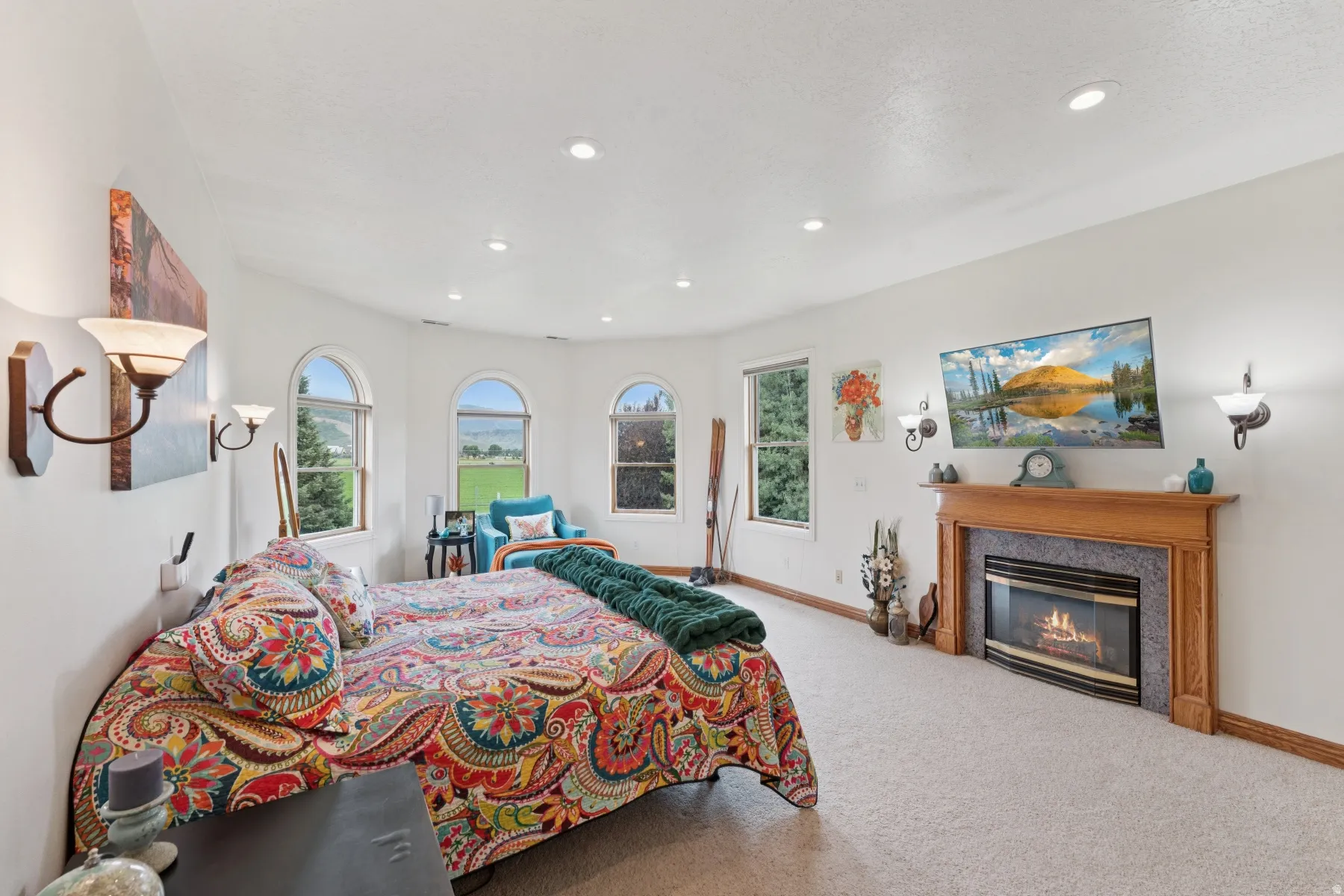Carpeted bedroom with multiple windows, a high end fireplace, and recessed lighting