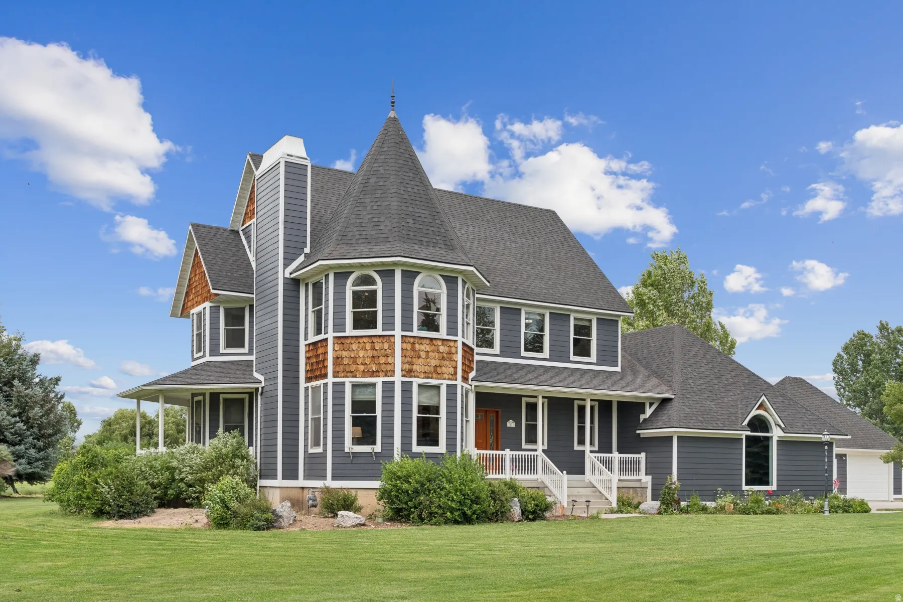 Back of property with a porch, a yard, roof with shingles, and a chimney
