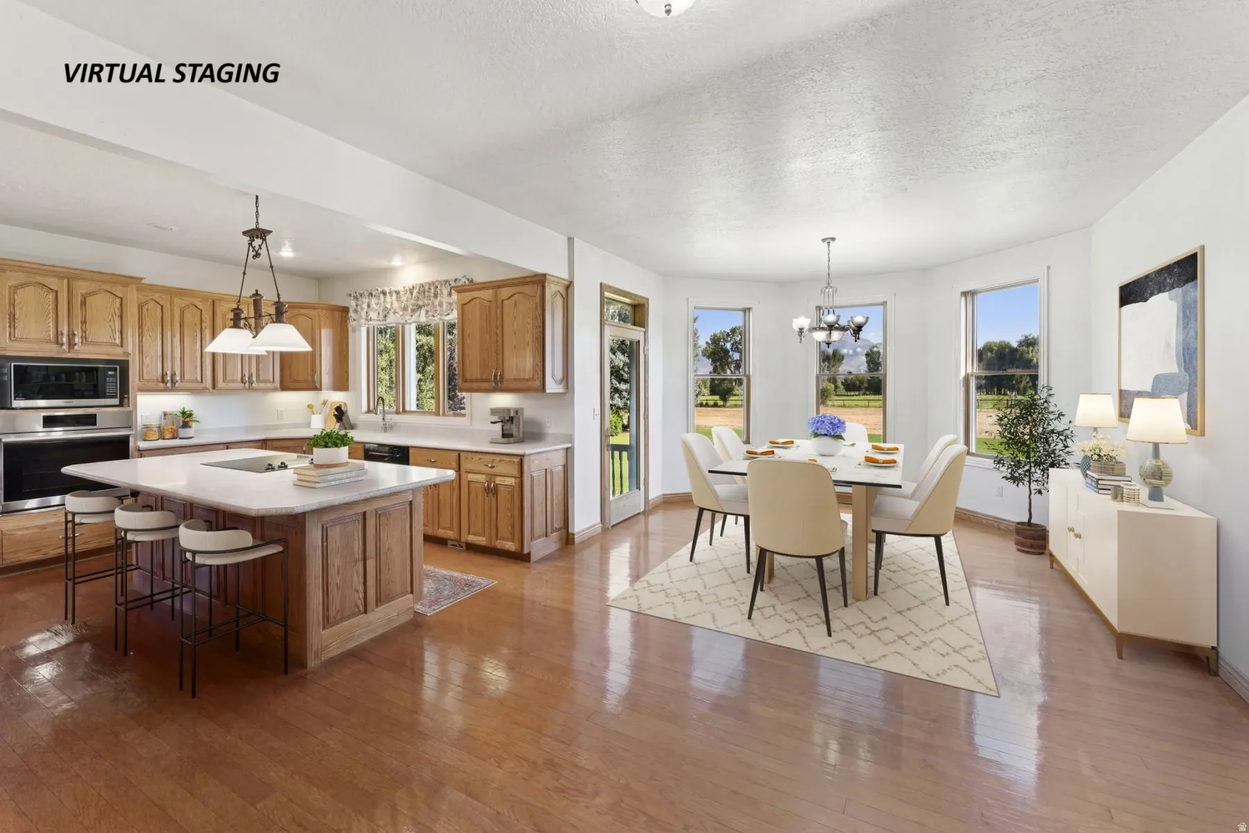 Kitchen with stainless steel appliances, light countertops, a textured ceiling, a kitchen island, and hanging lights