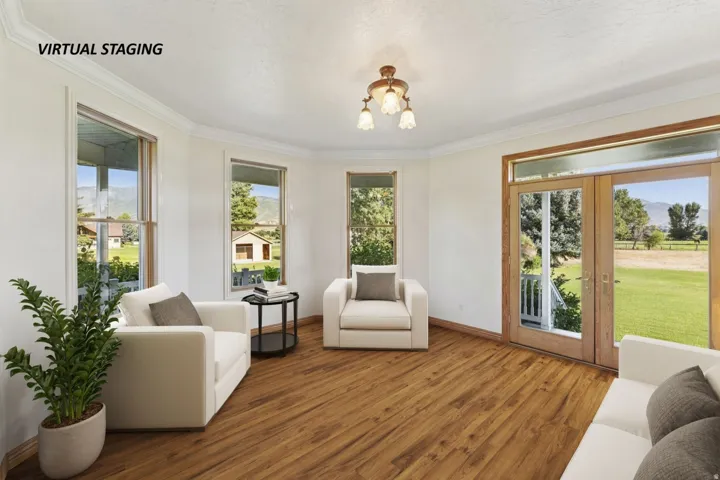 Sitting room with french doors, wood finished floors, hanging lights, and ornamental molding