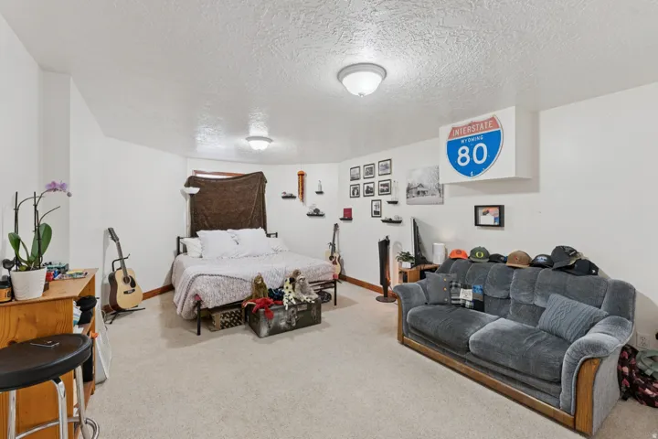 Bedroom with a textured ceiling and light carpet