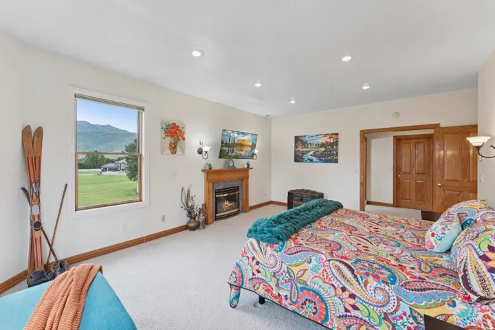 Bedroom with light carpet, a premium fireplace, and recessed lighting