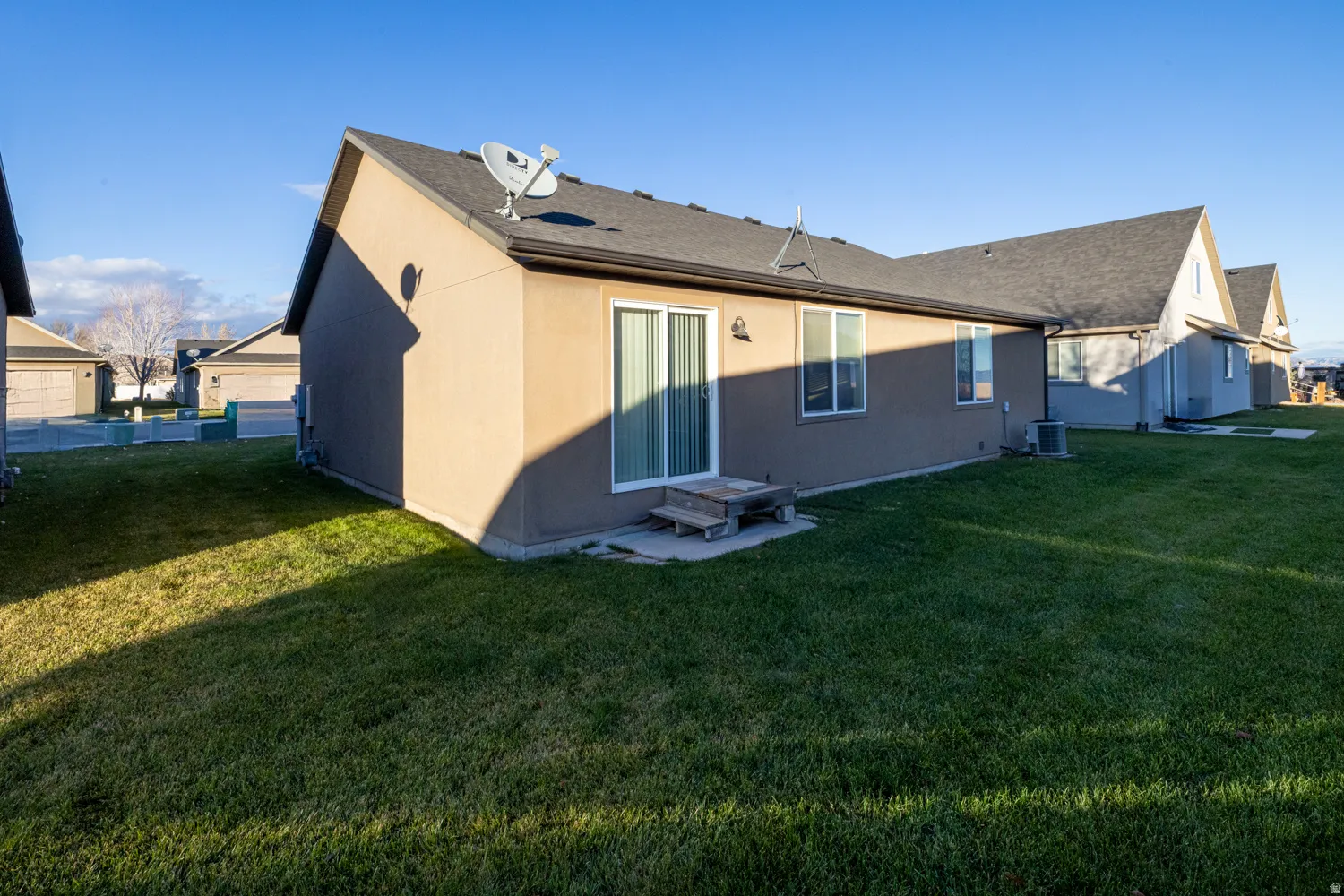 Rear view of property featuring a lawn and roof with shingles