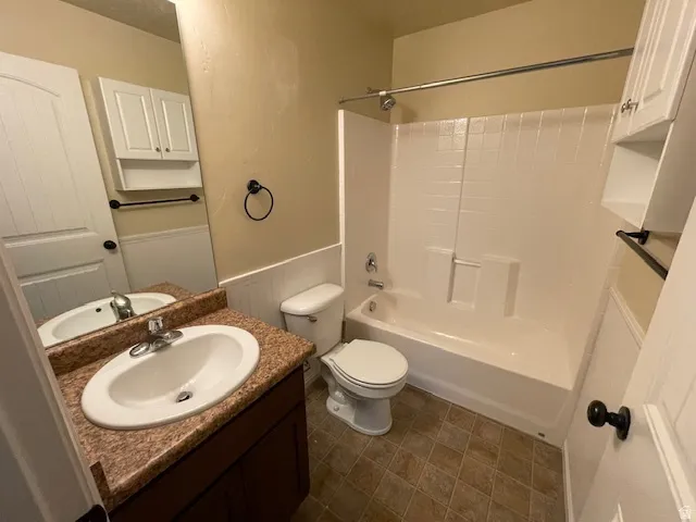 Bathroom featuring vanity, a wainscoted wall, and tub / shower combination