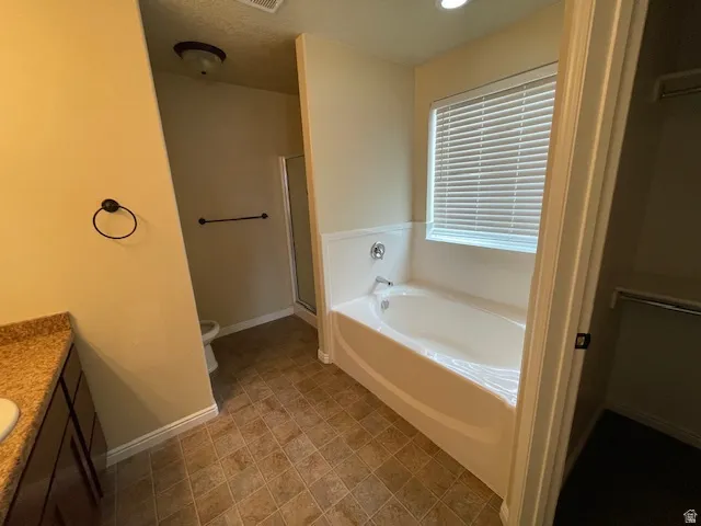 Full bathroom featuring vanity, a bath, and a shower stall