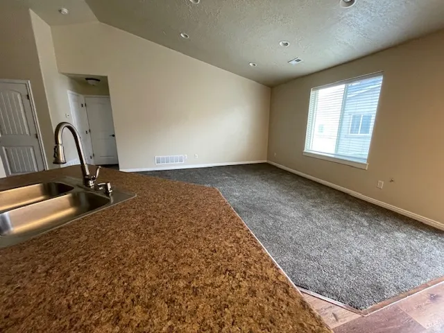 Kitchen featuring dark colored carpet and open floor plan
