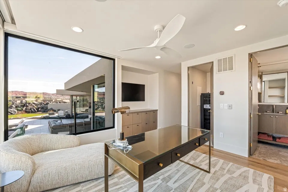 Living room with ceiling fan, light wood-style flooring, and recessed lighting