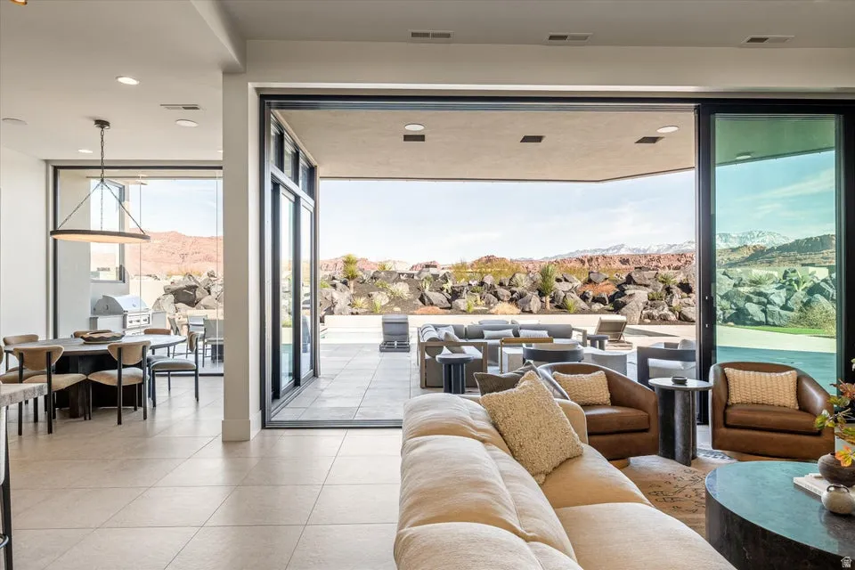 Living room featuring a mountain view, floor to ceiling windows, light tile patterned floors, and recessed lighting