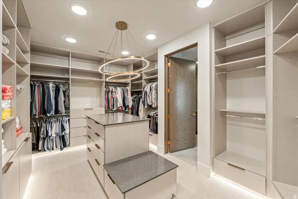 Walk in closet featuring light colored carpet