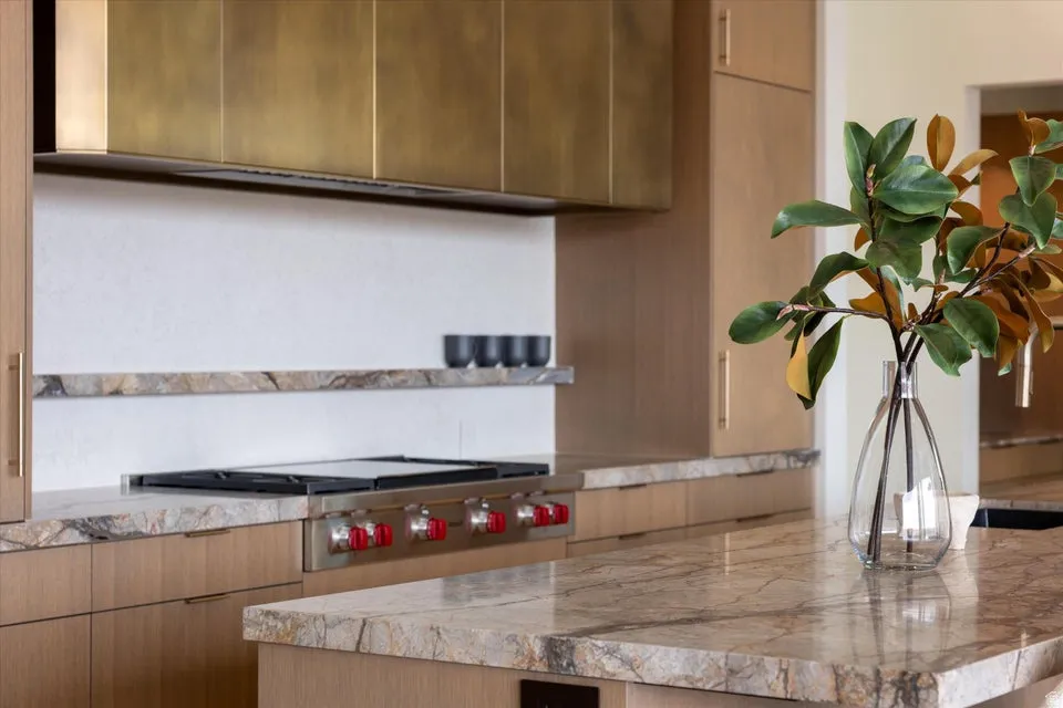 Kitchen with modern cabinets, light countertops, extractor fan, and stainless steel gas stovetop