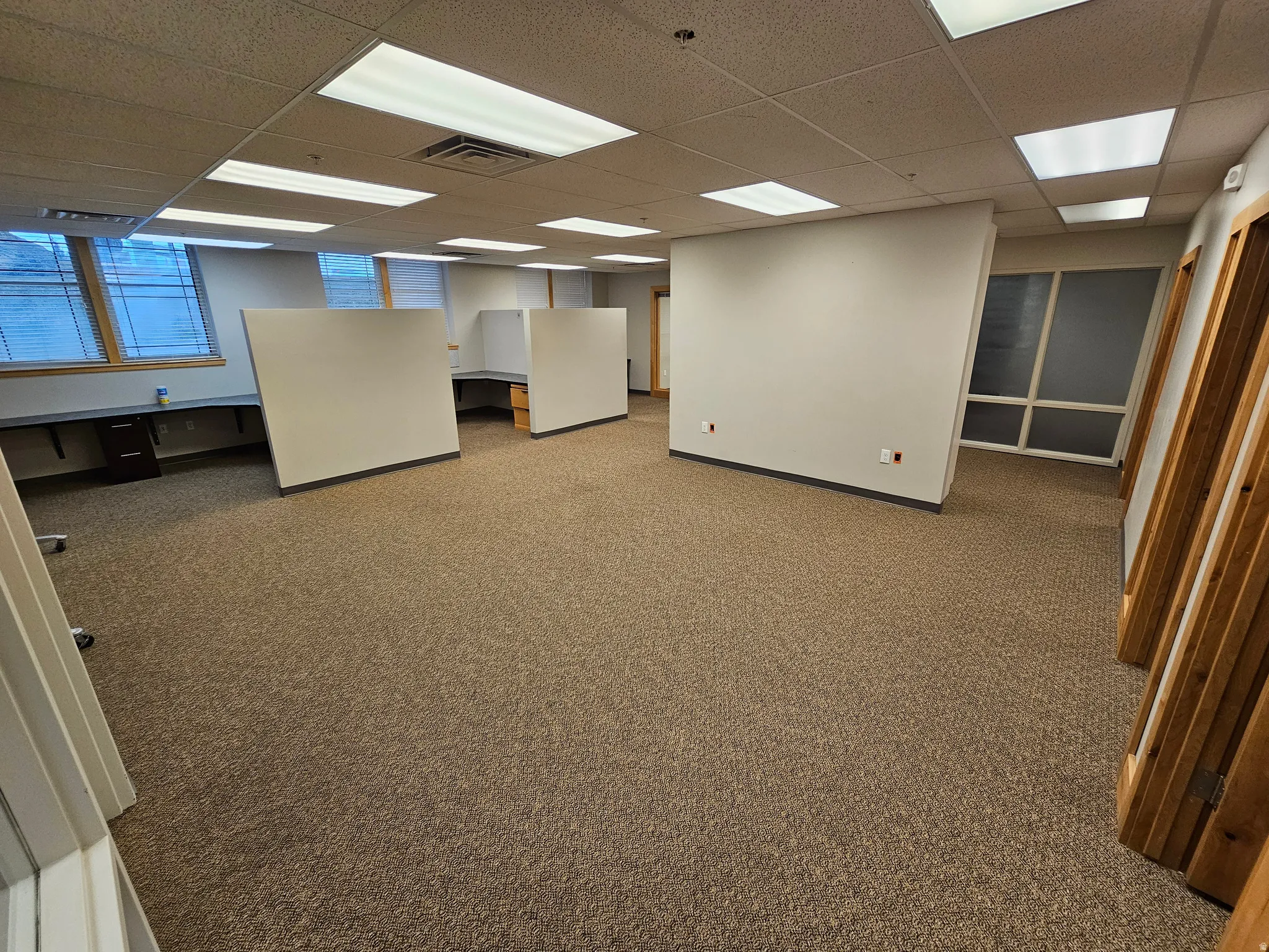 Basement featuring light carpet and a paneled ceiling