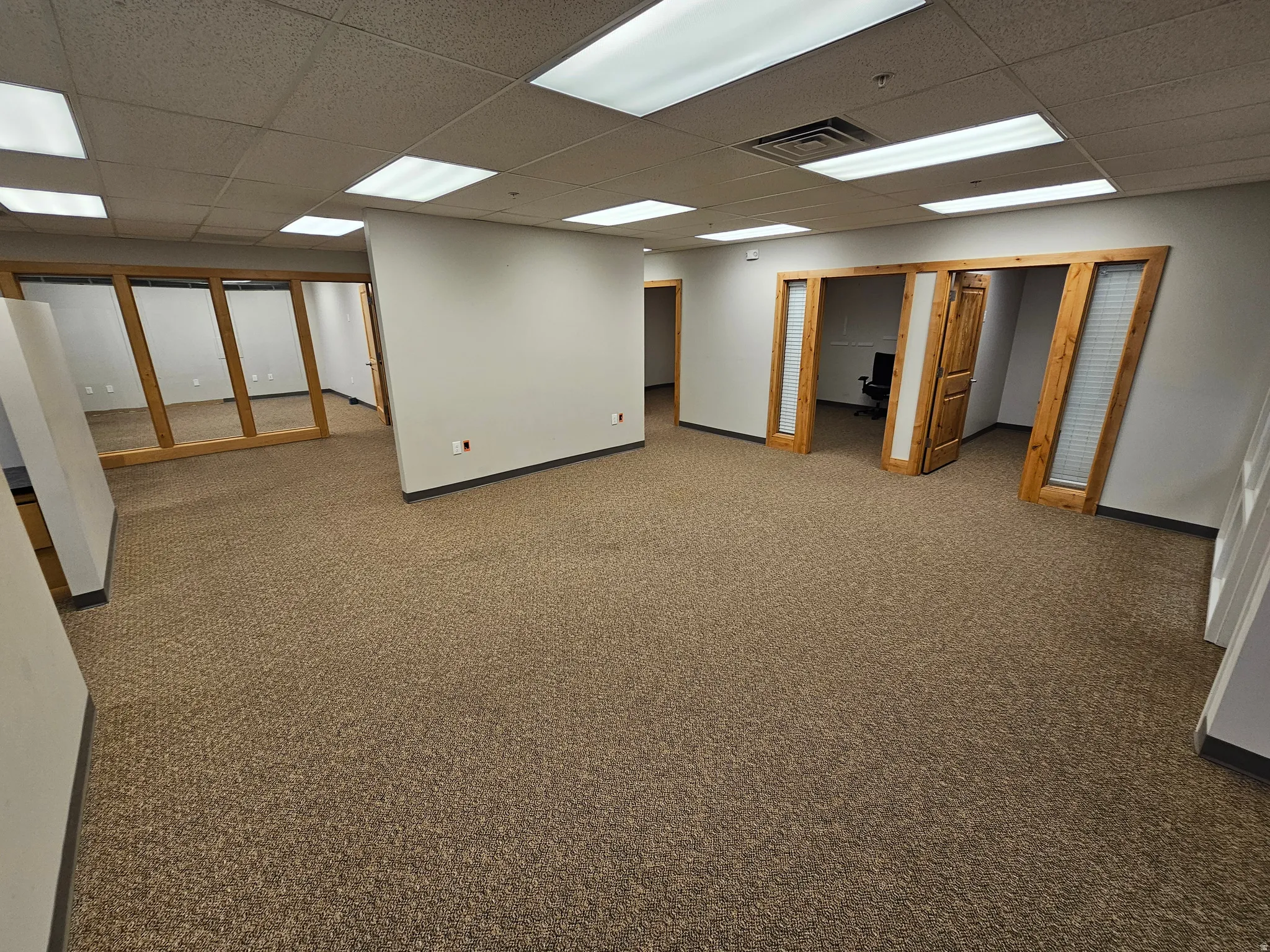 Basement with carpet flooring and a paneled ceiling
