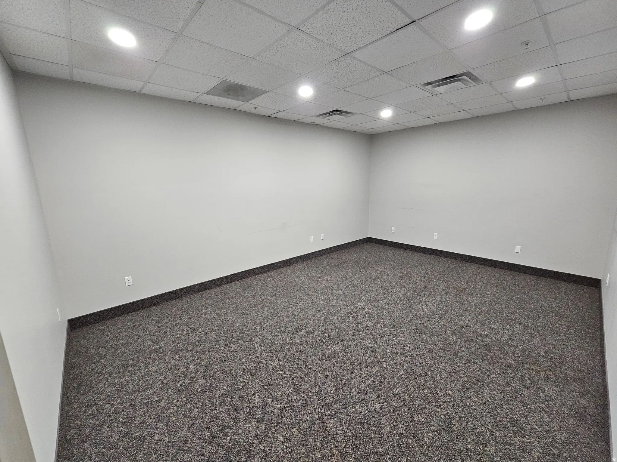 Unfurnished room with a drop ceiling, carpet floors, and recessed lighting