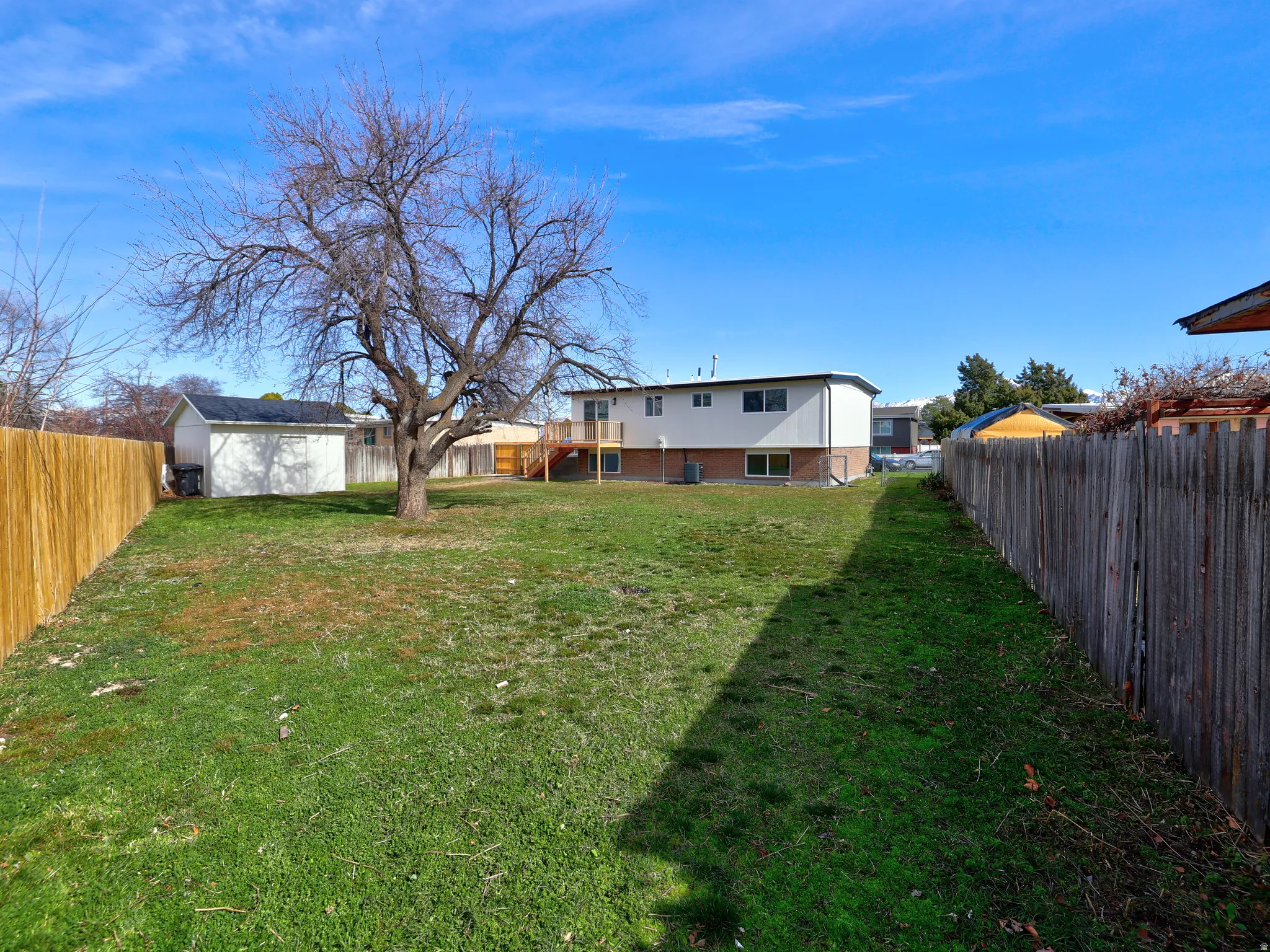 Rear view of property featuring a fenced backyard and a shed