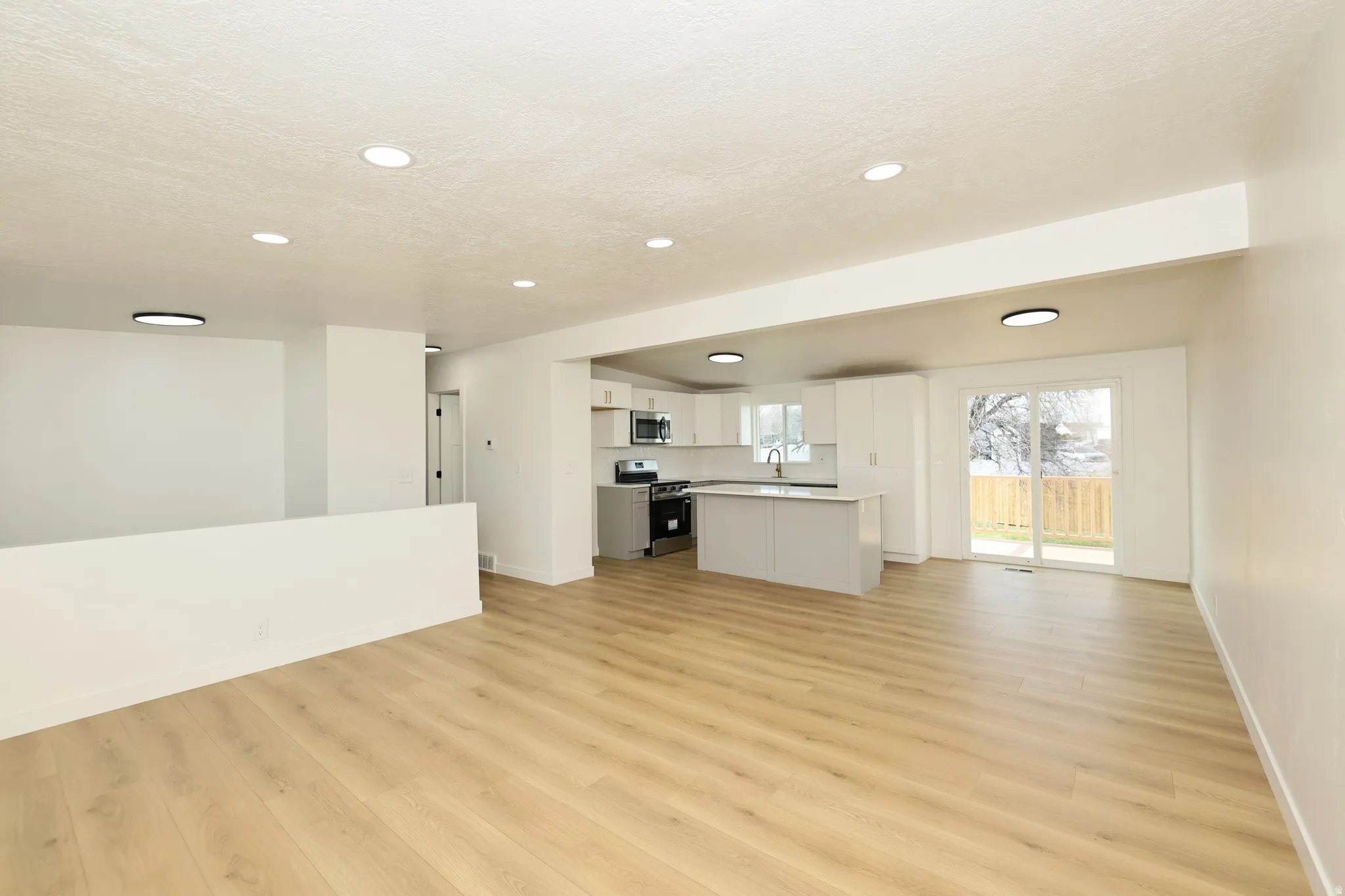 Unfurnished living room with light wood finished floors and recessed lighting