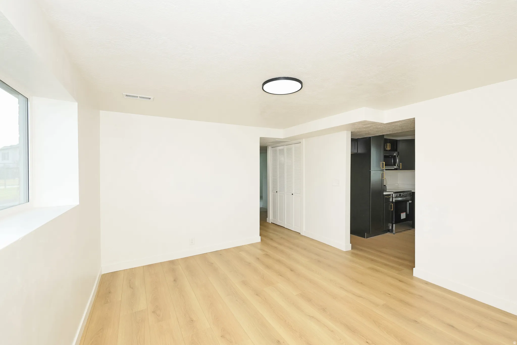Empty room with light wood-type flooring and baseboards
