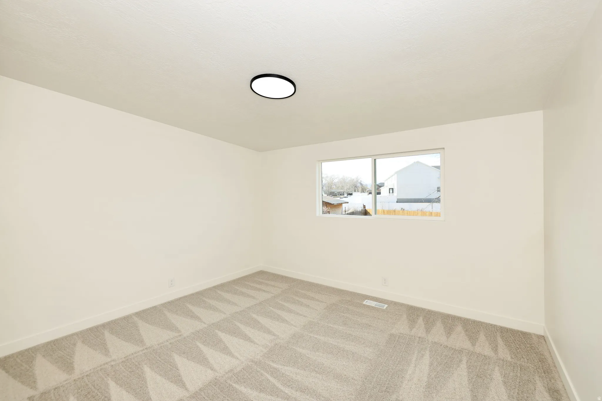 Unfurnished room with baseboards and light colored carpet
