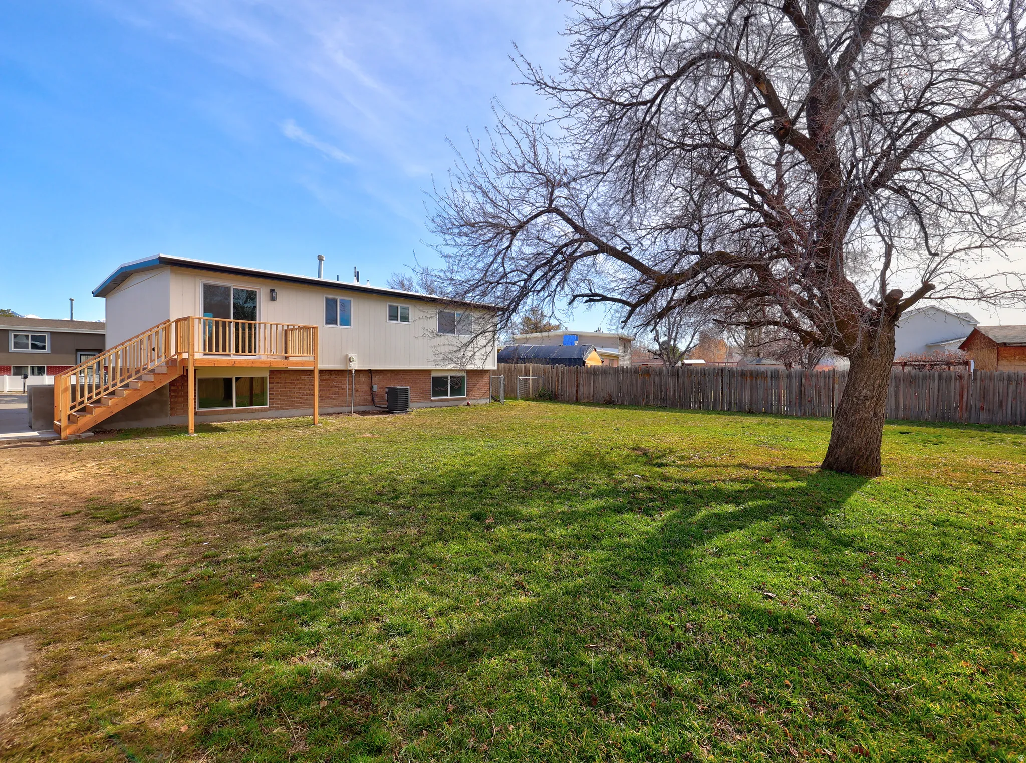 Rear view of property with brick siding and a deck