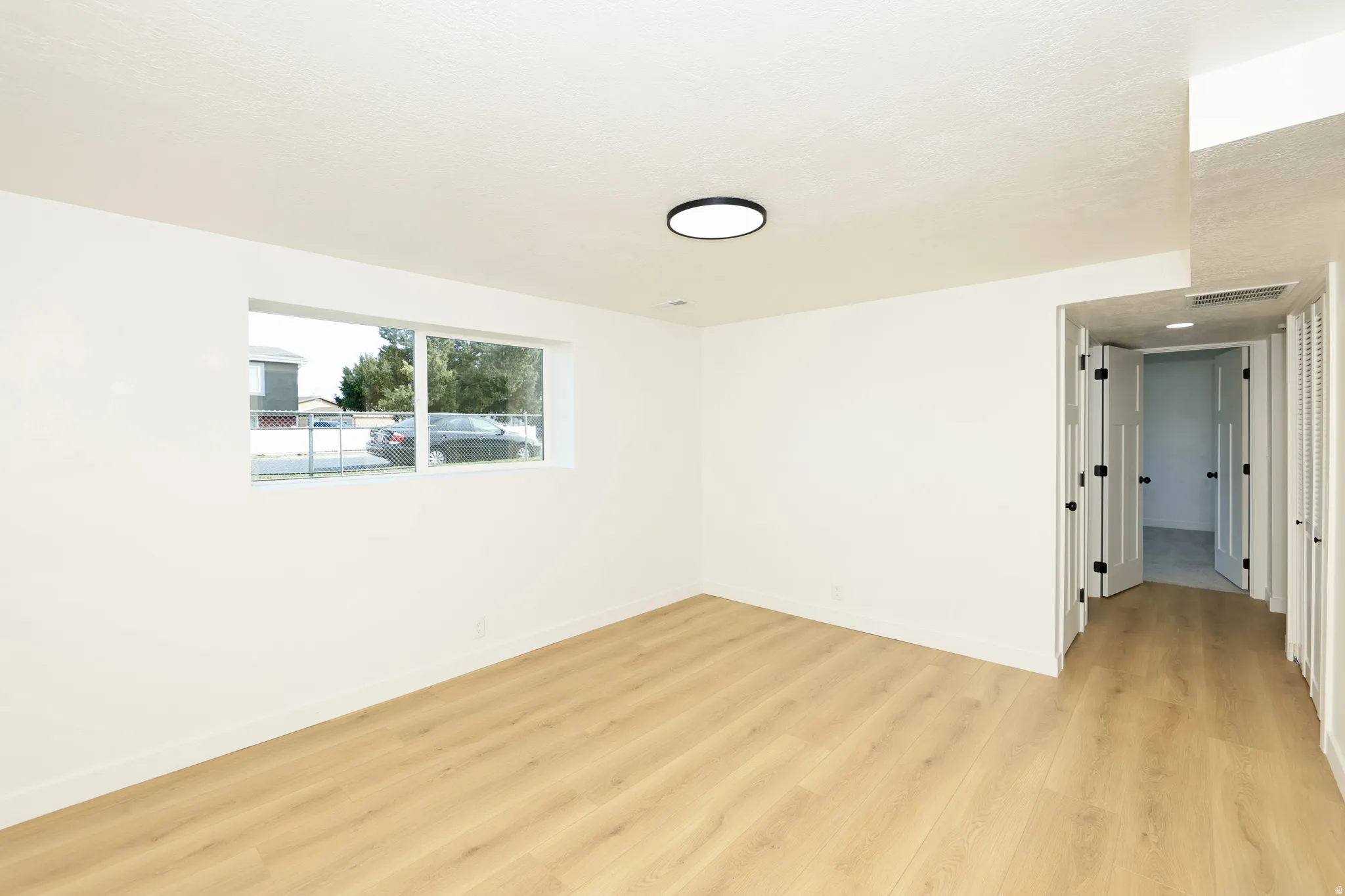 Spare room featuring light wood-style floors and baseboards