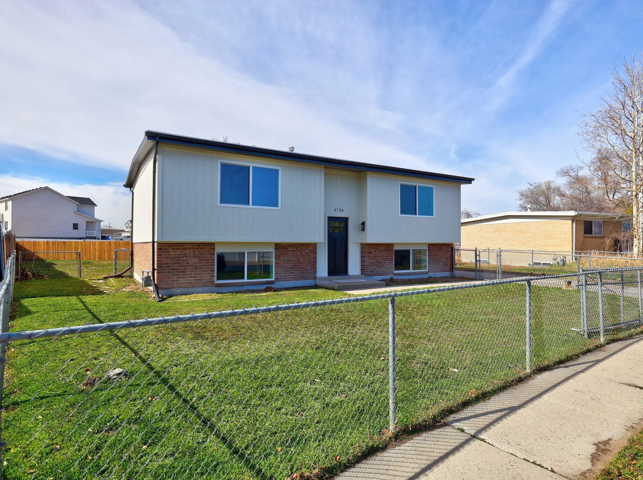 View of front of property with brick siding and a fenced backyard