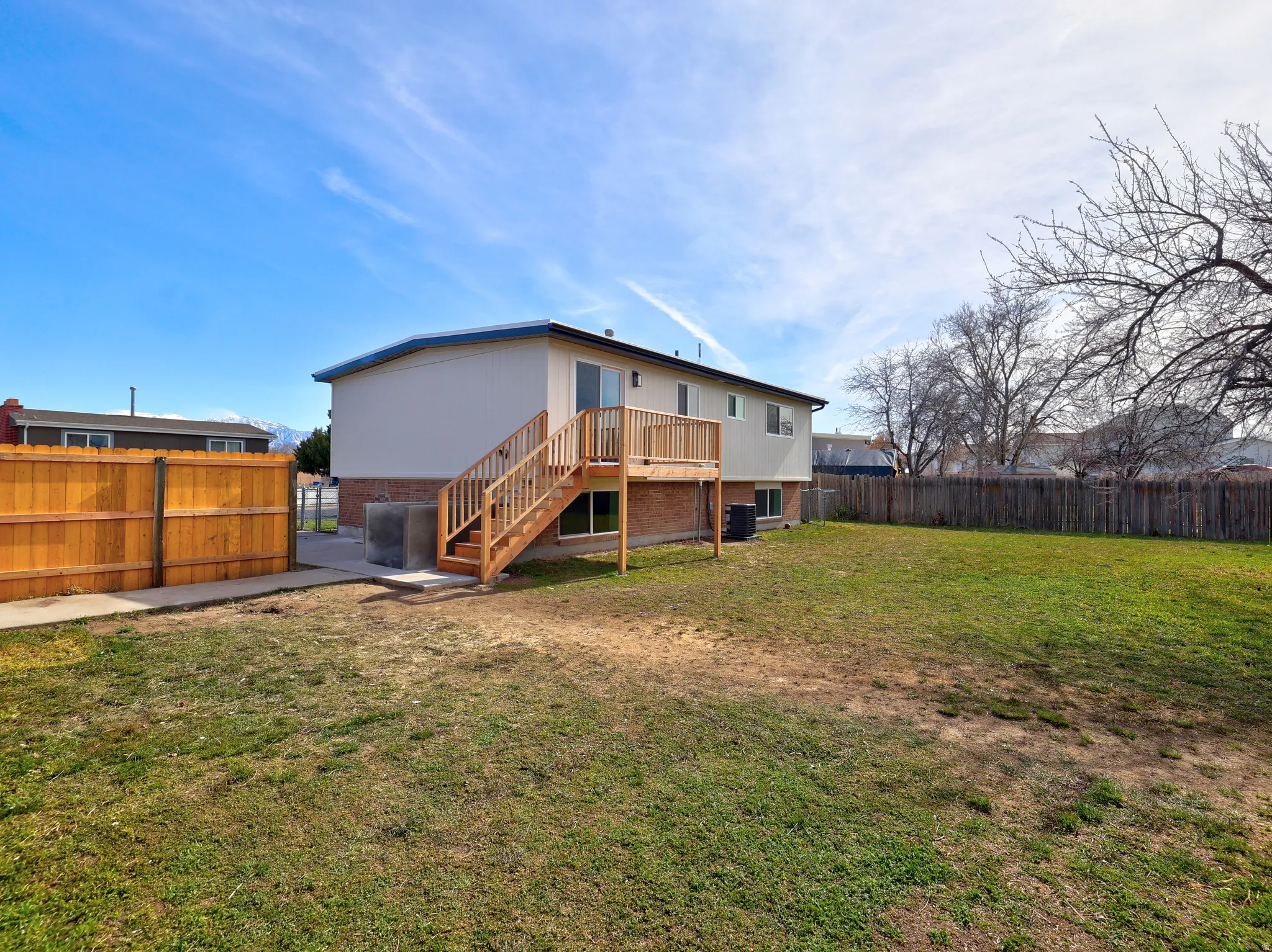 Rear view of property with a fenced backyard, brick siding, and a gate