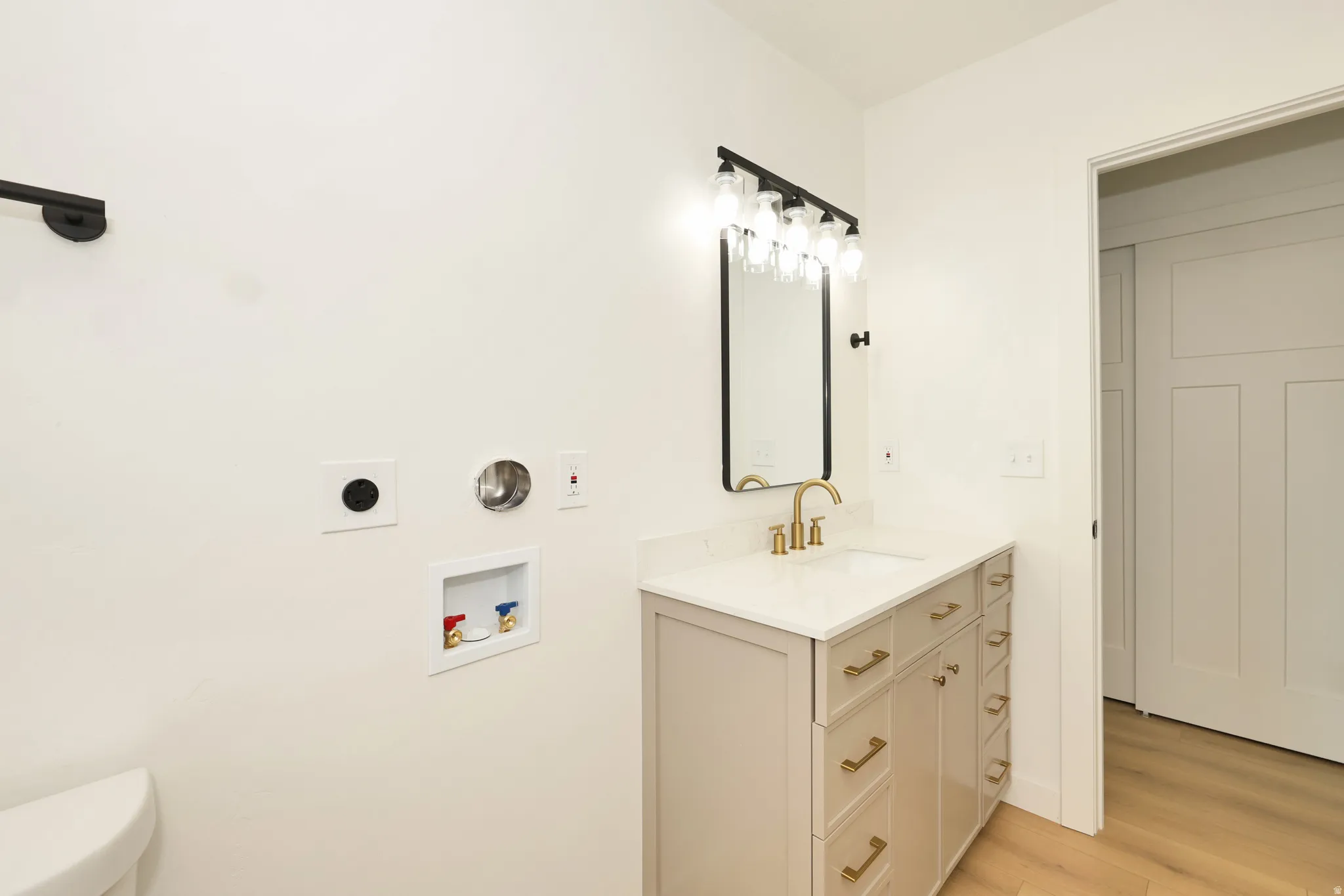 Half bathroom with vanity and light wood finished floors