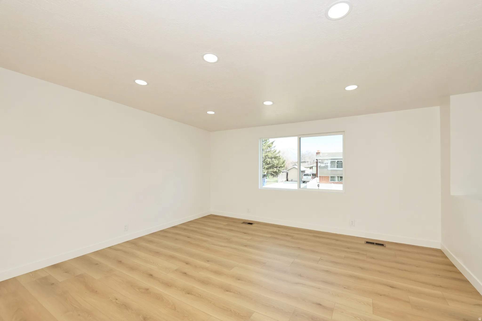 Unfurnished room with light wood-type flooring and recessed lighting