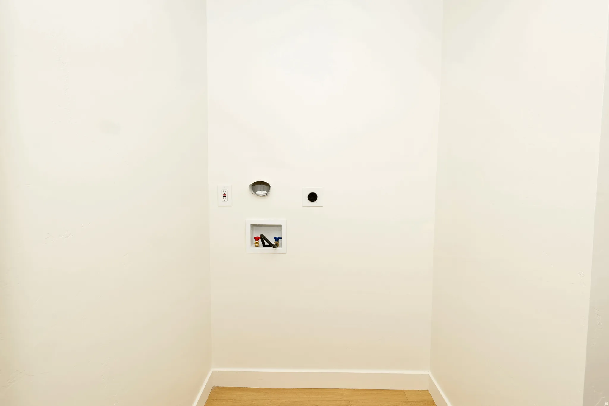 Laundry room with light wood finished floors, washer hookup, and electric dryer hookup