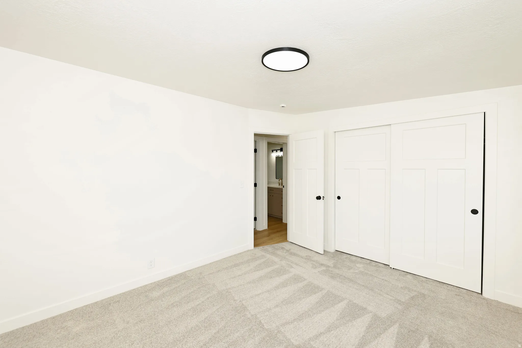 Unfurnished bedroom featuring light colored carpet and a closet