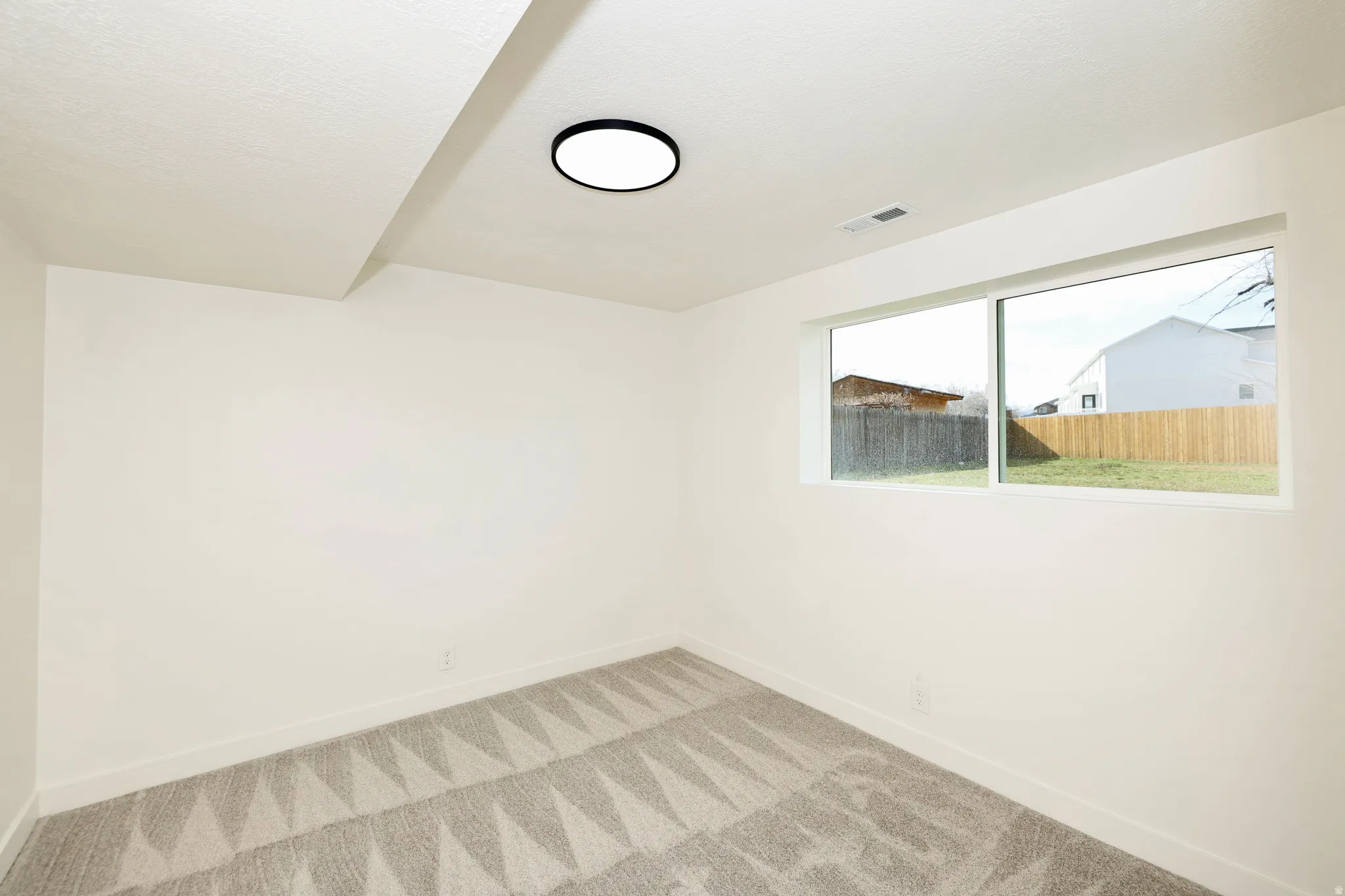 Spare room with baseboards and light carpet