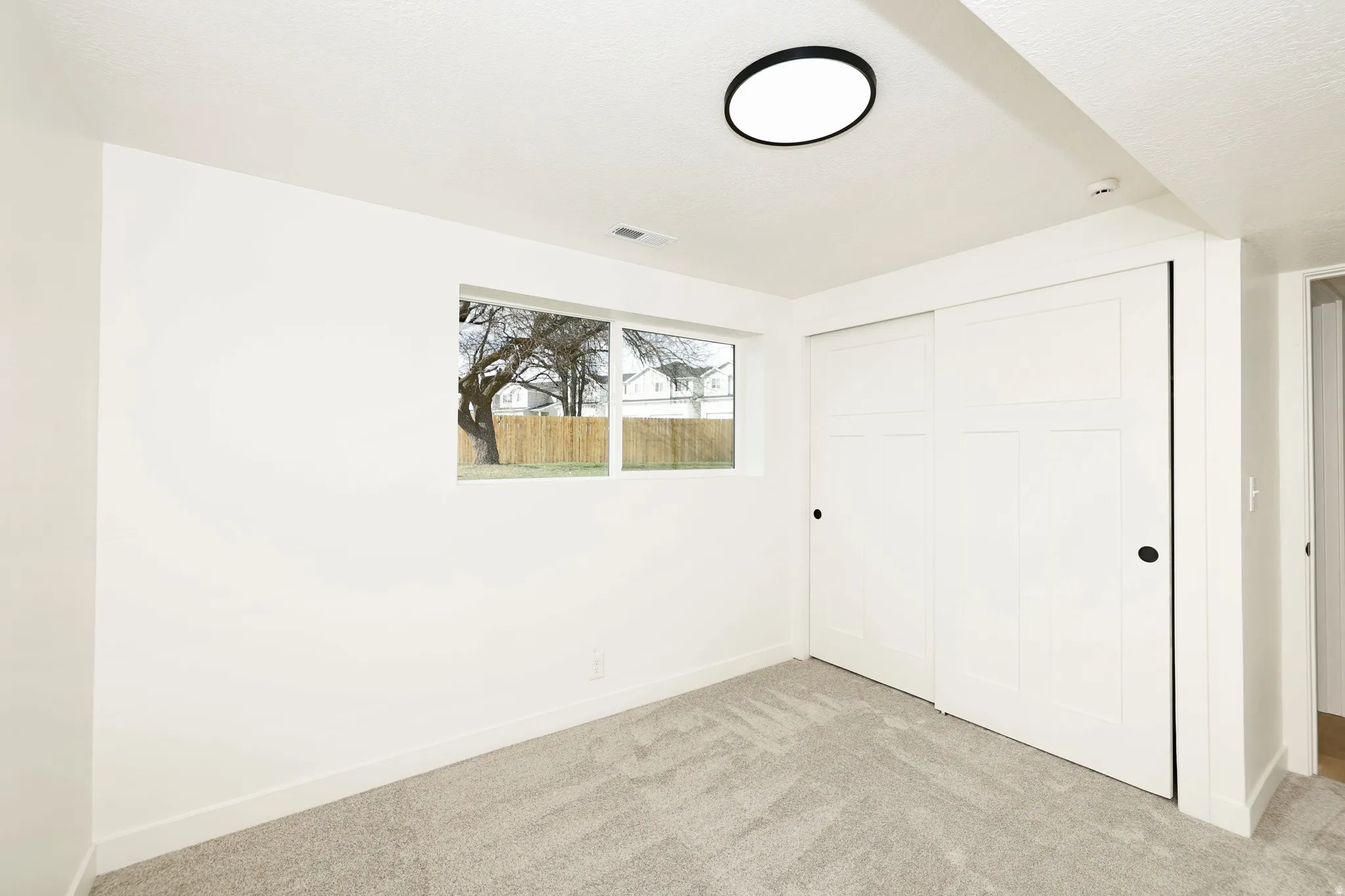 Unfurnished bedroom with light carpet and a closet