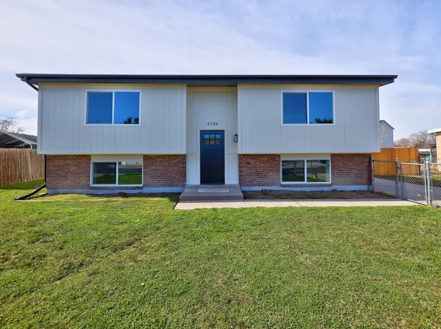Split foyer home featuring brick siding and a gate