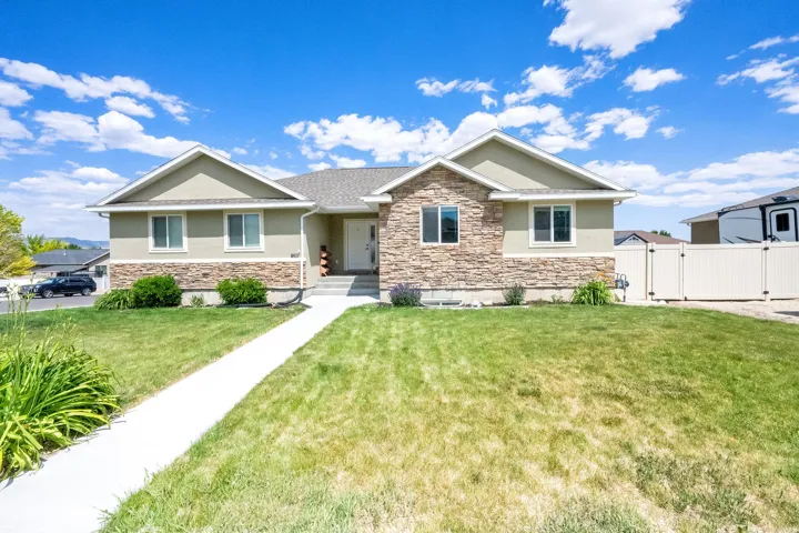 View of front of house with stone siding, a gate, and stucco siding