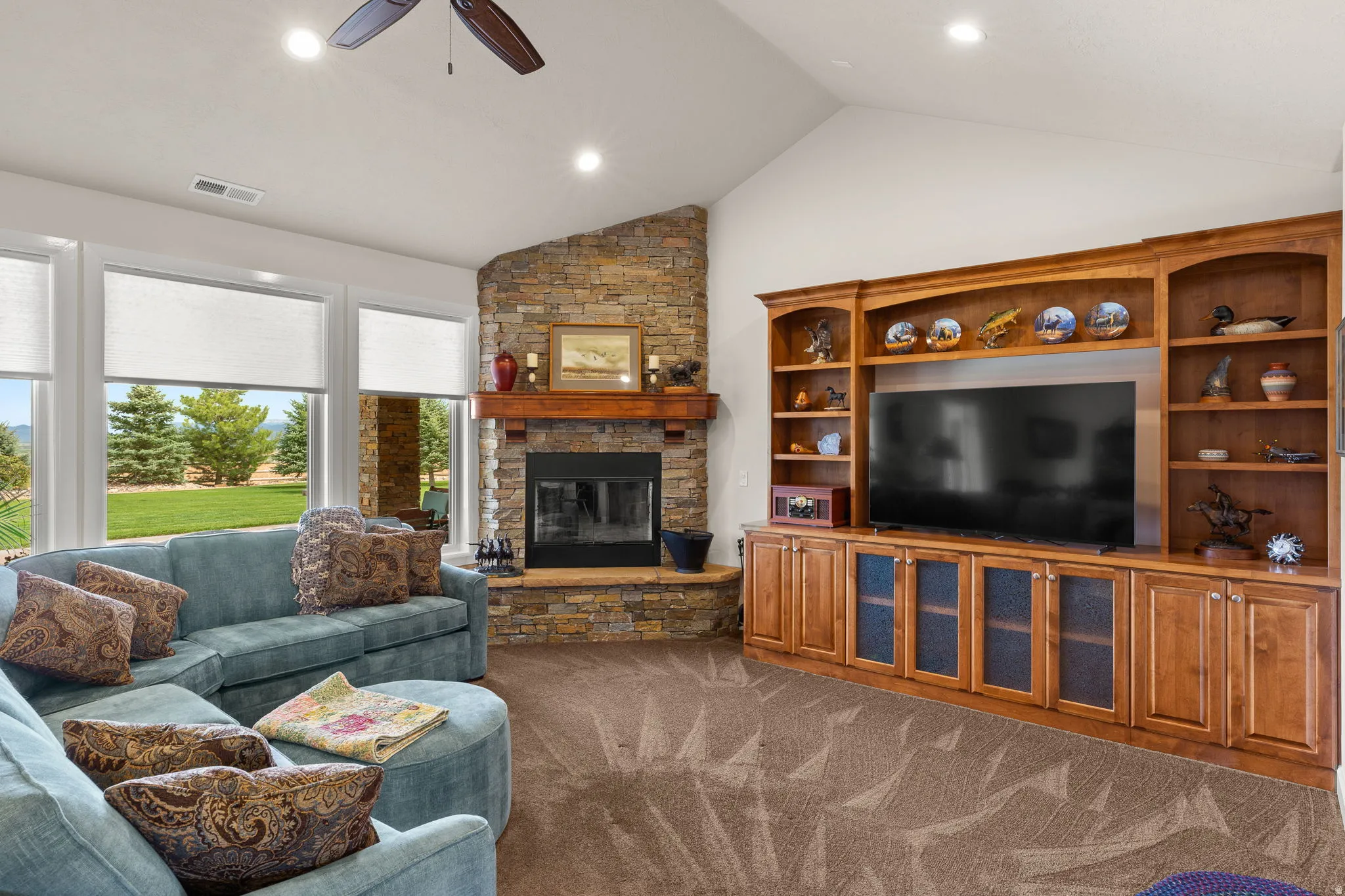 Living room with a ceiling fan, recessed lighting, dark colored carpet, and a fireplace