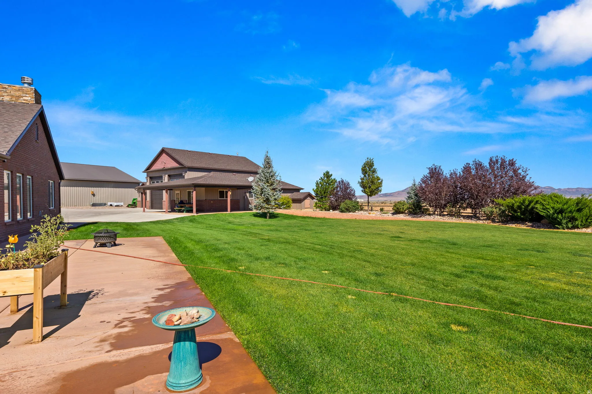 View of grassy yard featuring a patio area