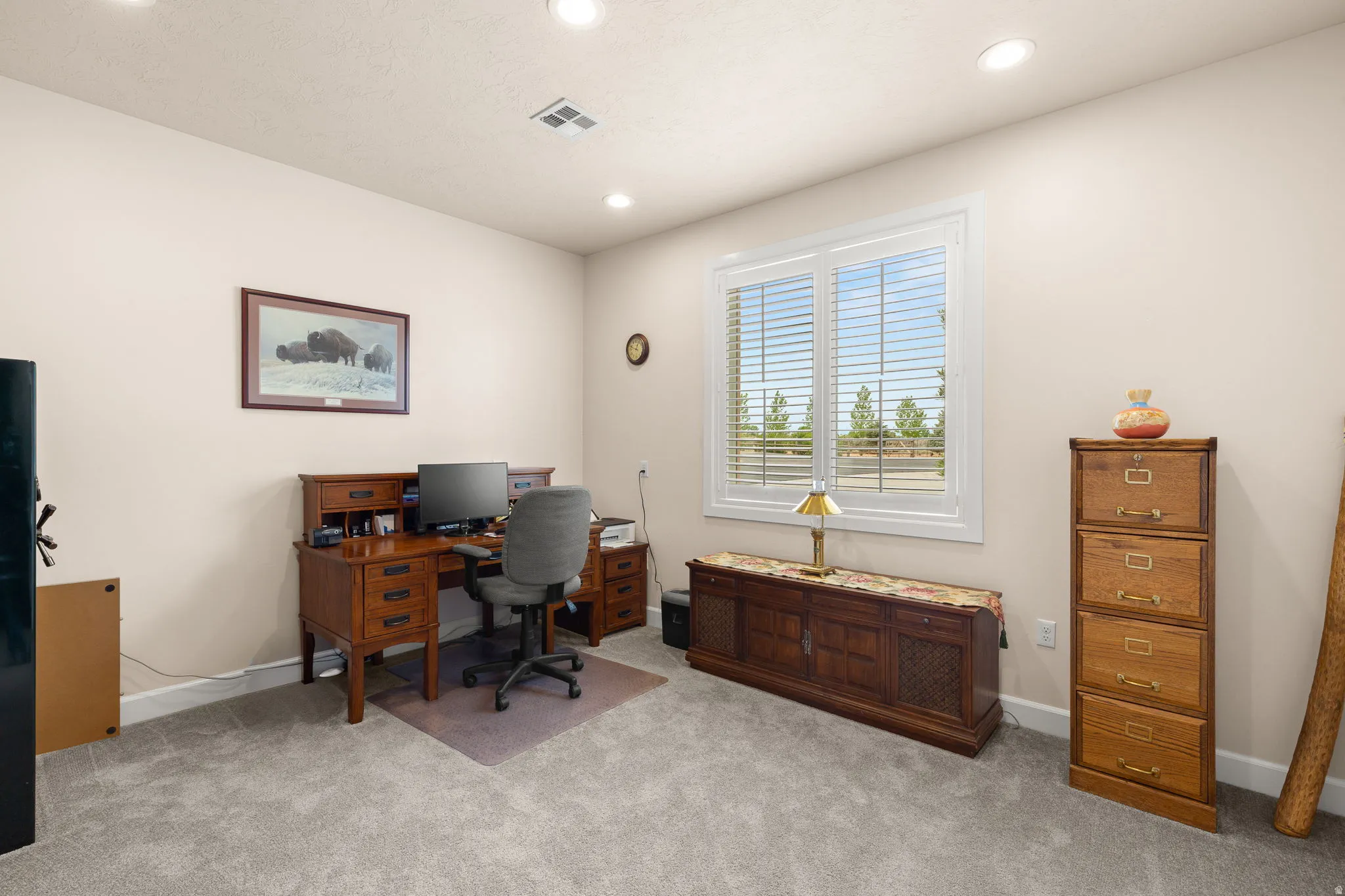 Office space with light carpet and recessed lighting