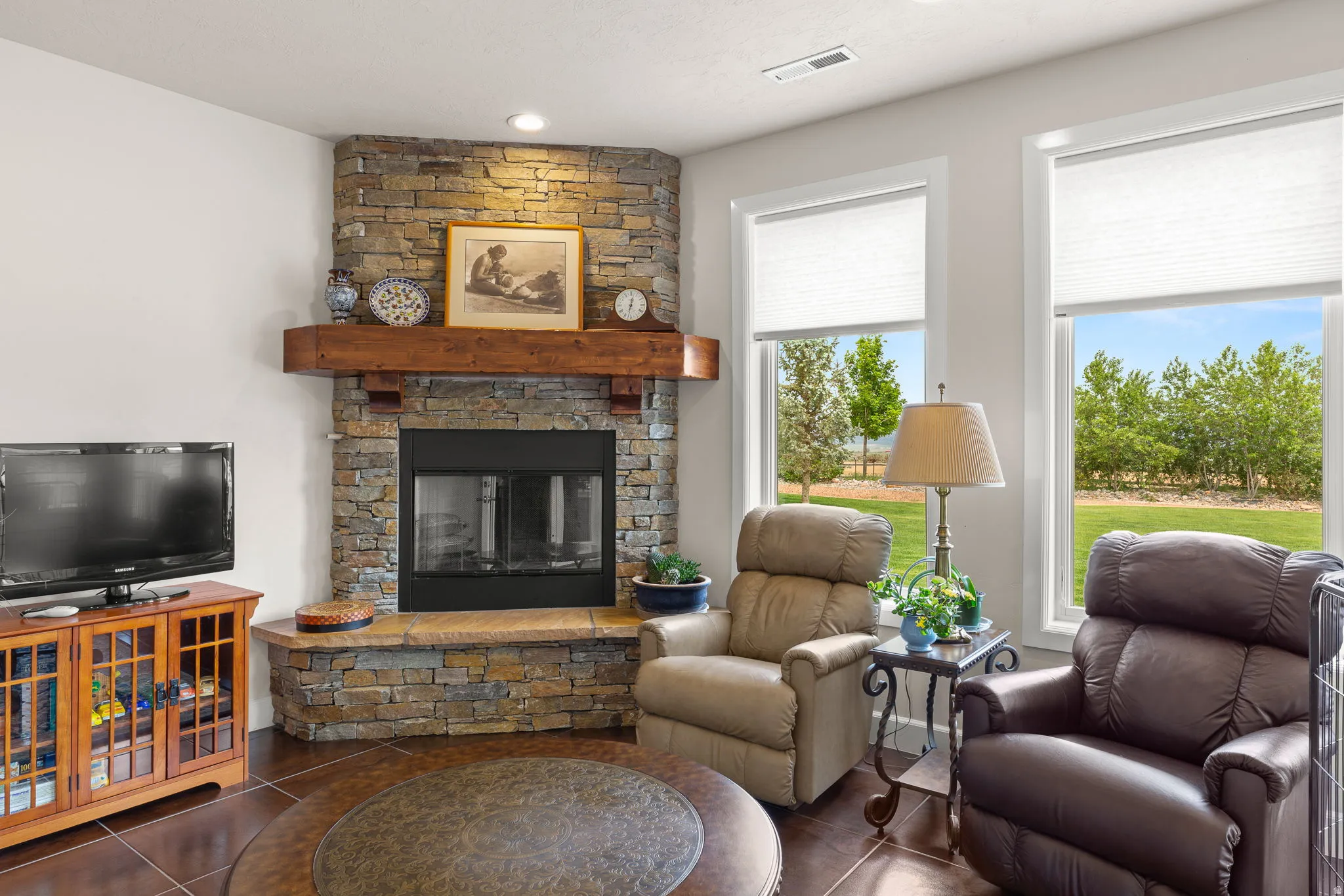 Tiled living area with a stone fireplace