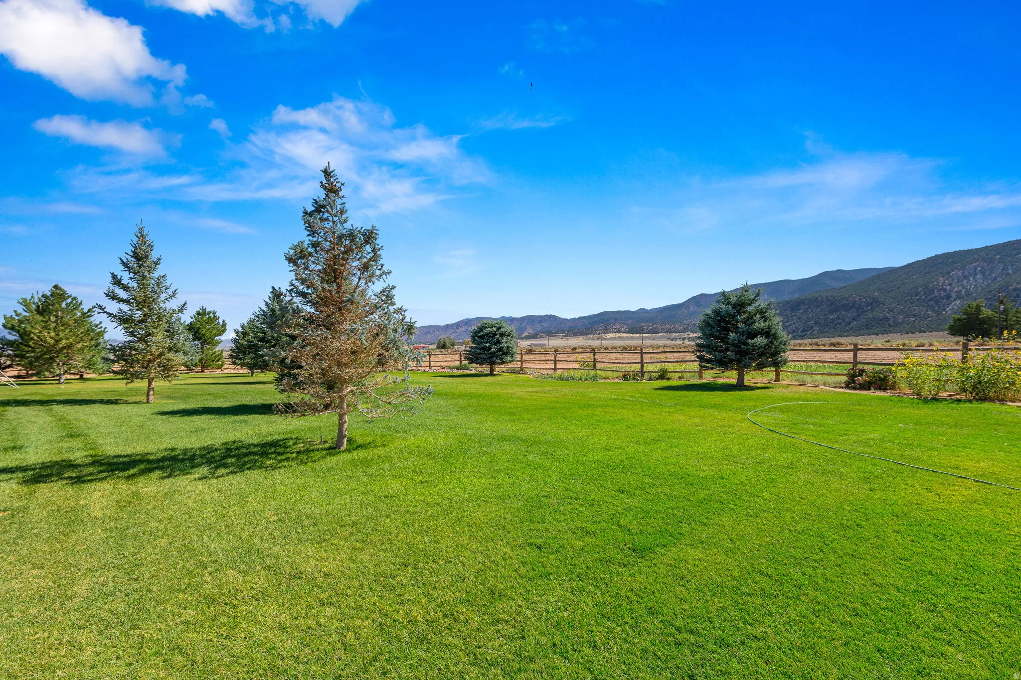View of green lawn with a rural view and a mountain view