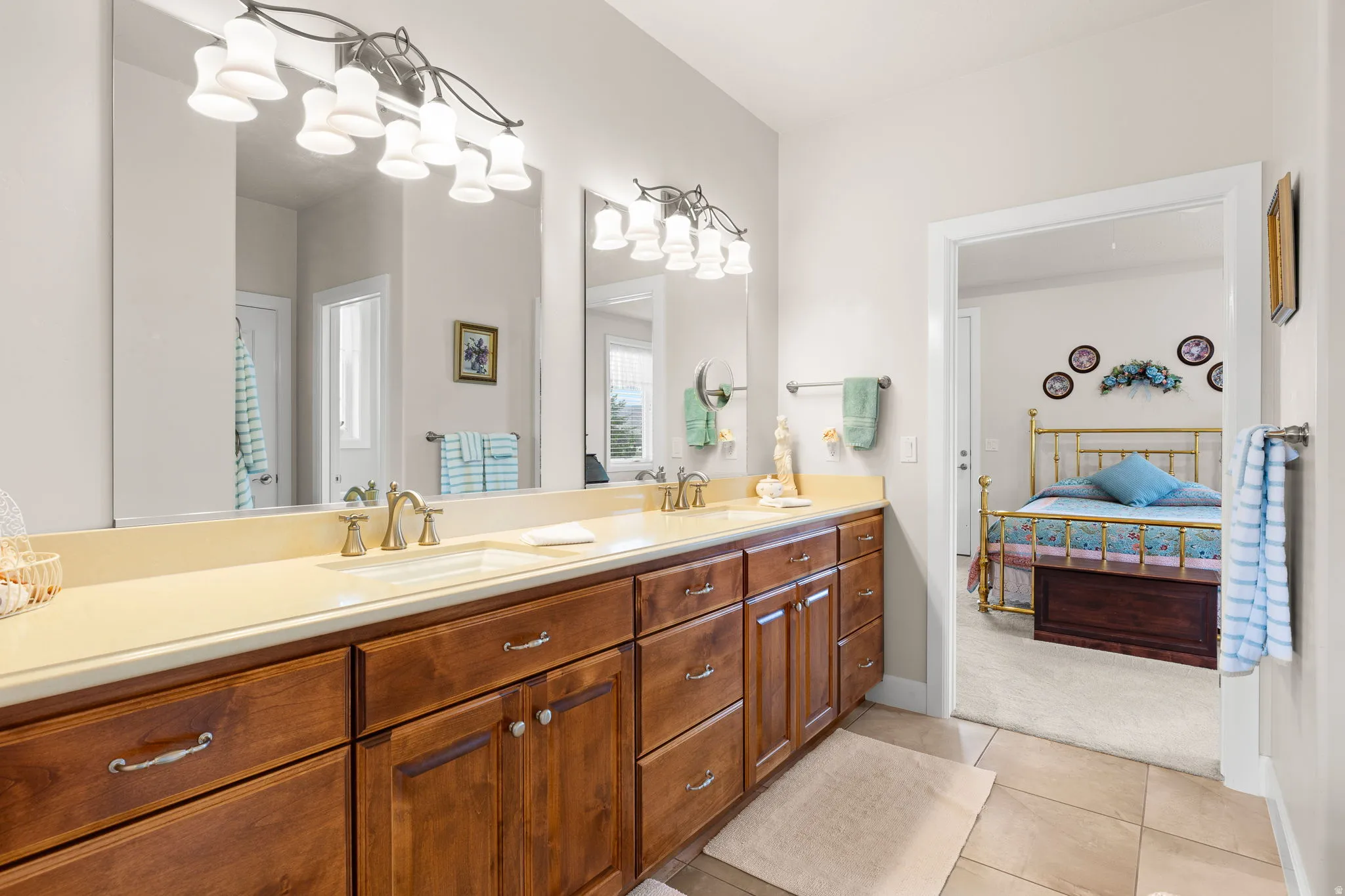 Ensuite bathroom featuring double vanity, light tile patterned floors, and light carpet