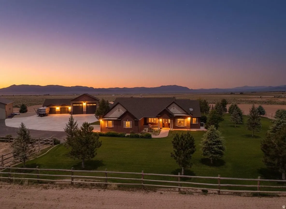 View of front of property with a fenced front yard, a detached garage, a mountain view, driveway, and a porch