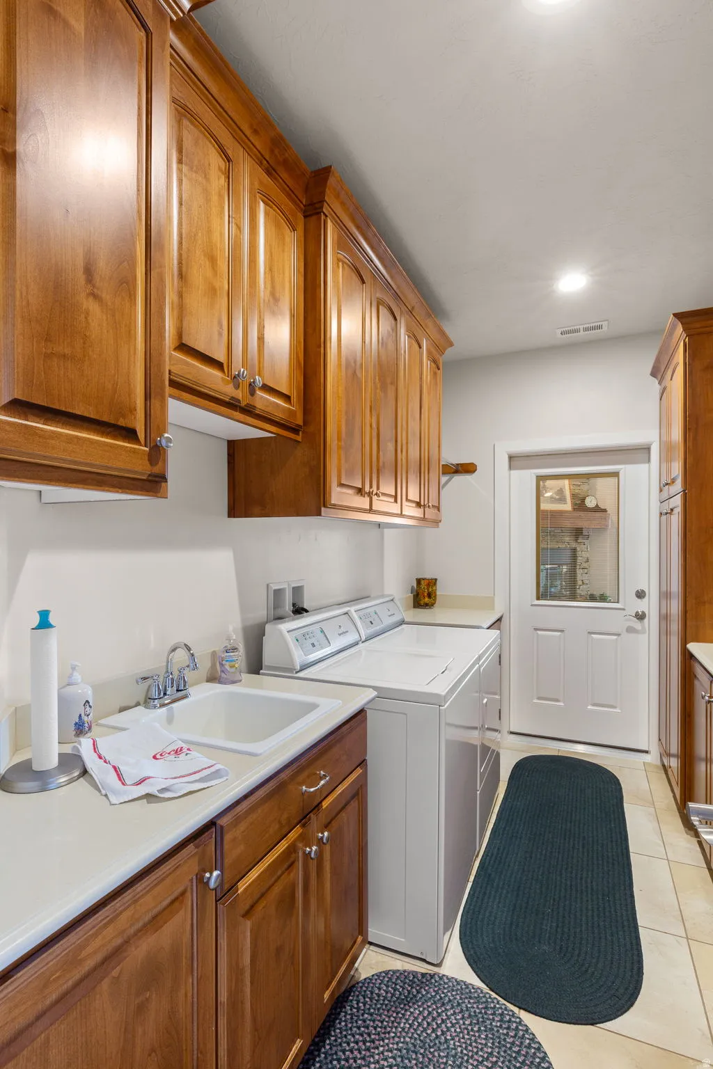 Laundry area with cabinet space, washing machine and dryer, light tile patterned floors, and recessed lighting