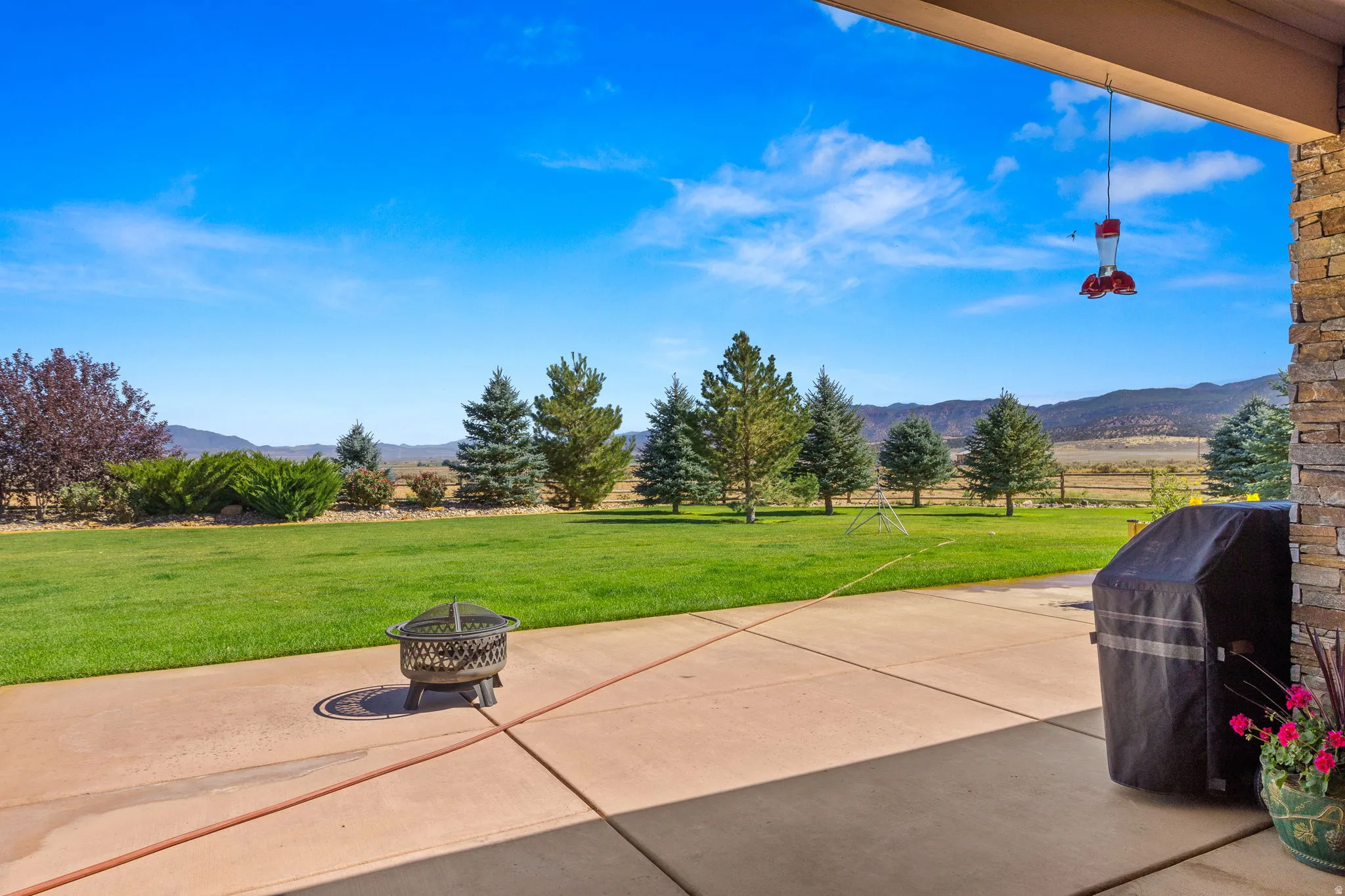 View of patio featuring a mountain view, an outdoor fire pit, a grill, and a view of rural / pastoral area