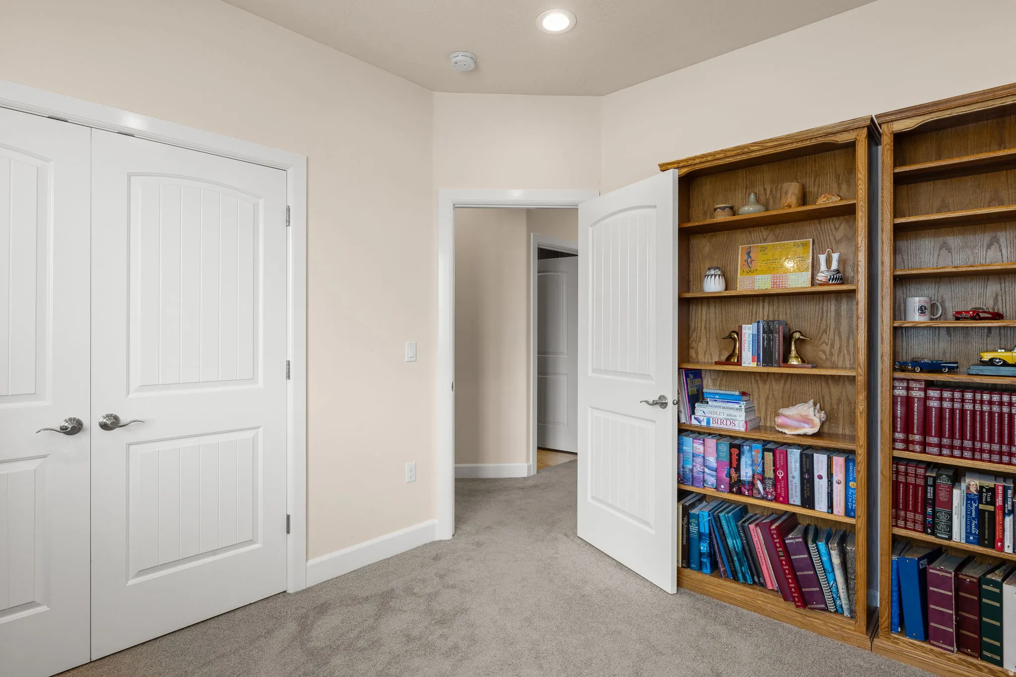 Bedroom with light colored carpet and a closet