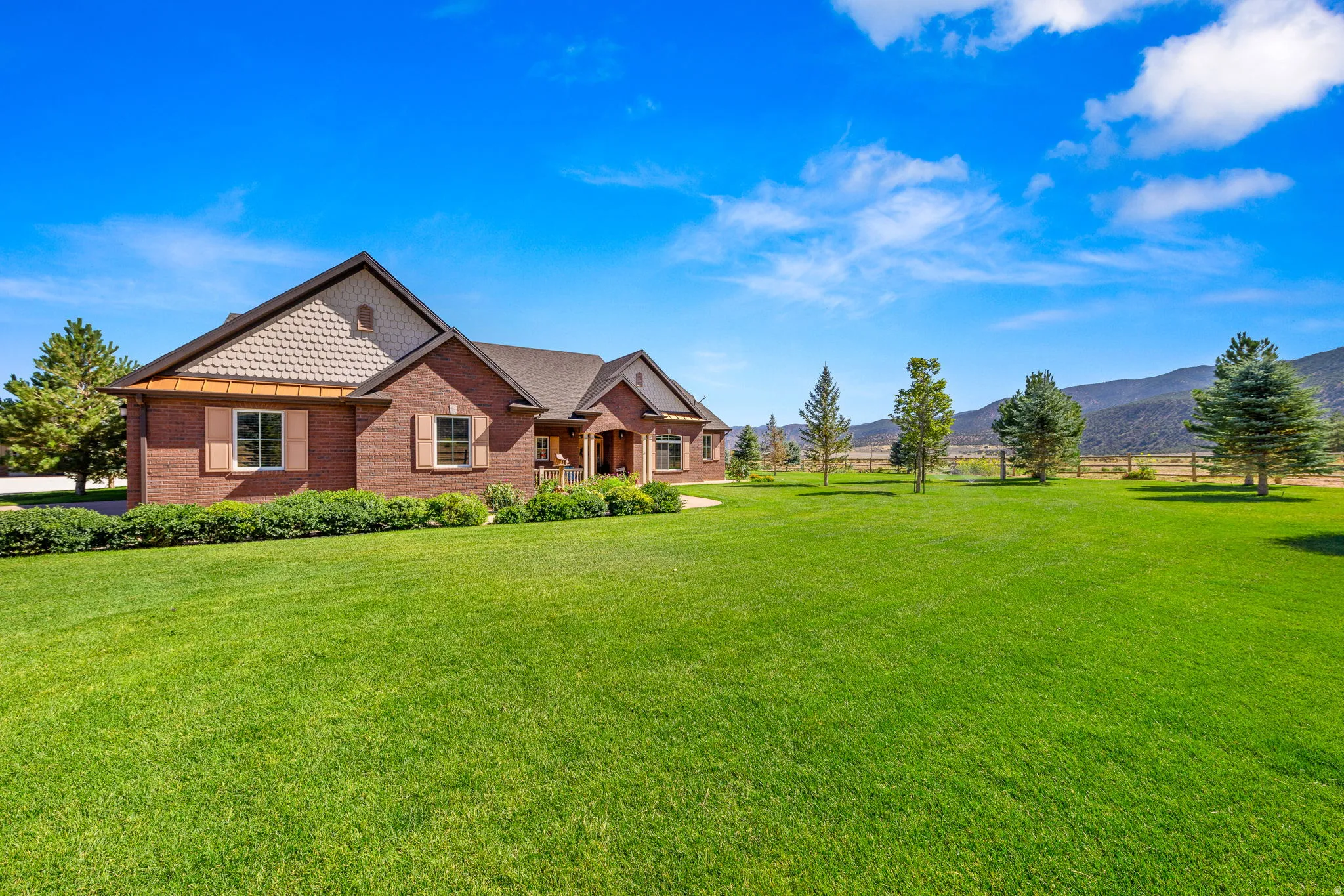 View of front facade featuring a front lawn, brick siding, and a mountain view