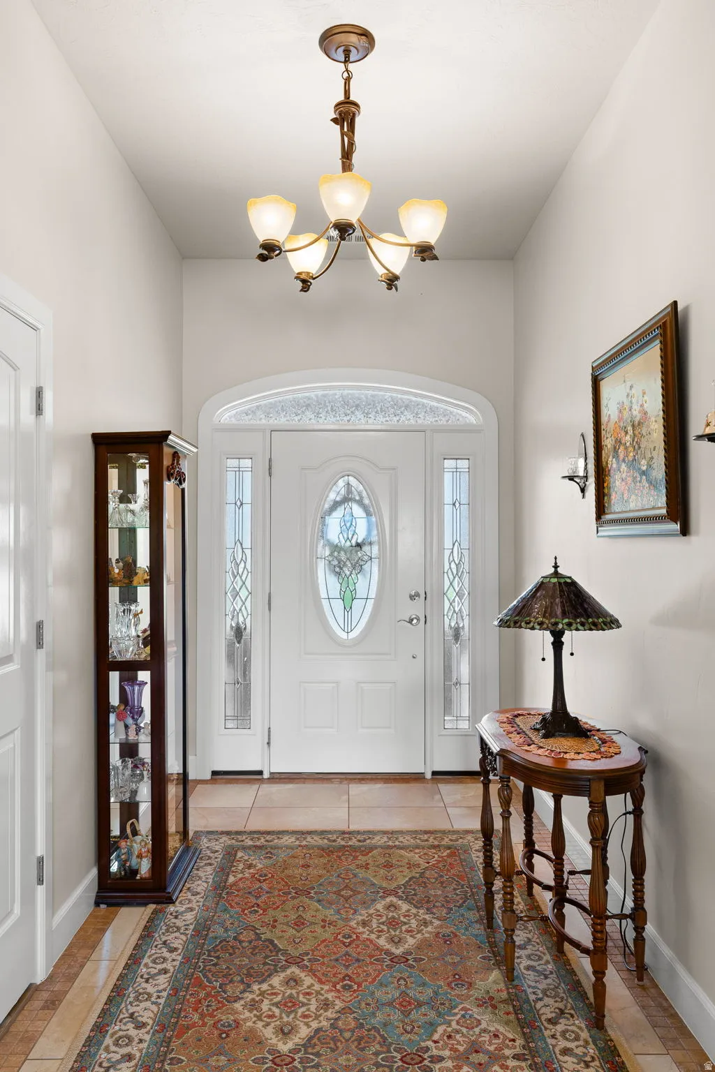 Foyer with healthy amount of natural light, hanging lights, and light tile patterned flooring