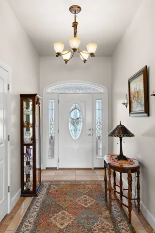 Foyer with healthy amount of natural light, hanging lights, and light tile patterned flooring