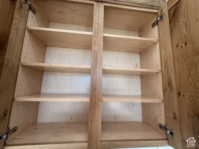 Wood-finish cabinetry with multiple adjustable shelves and soft-close hinges