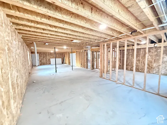 Expansive unfinished basement featuring wood framing, concrete flooring, and exposed ceiling joists