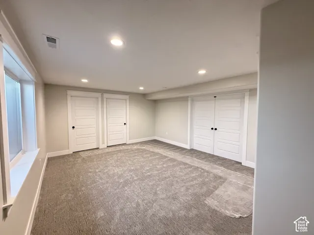 Recessed ceiling lighting, durable carpeting, clean white trim, and multiple panel doors