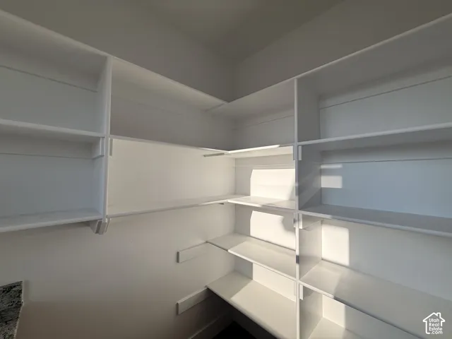 Built-in shelving with white finishes and a countertop featuring stone-finish material